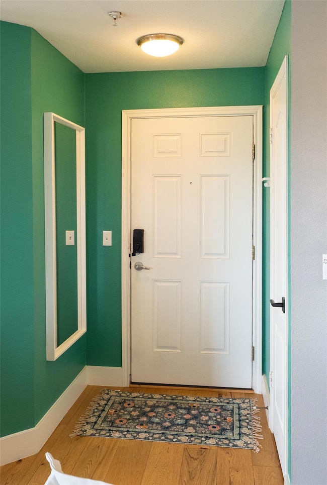 Entrance foyer with baseboards and wood finished floors