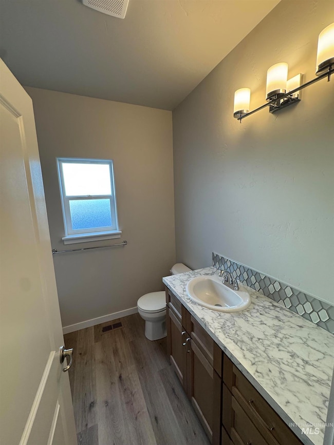Half bathroom featuring dark wood-style flooring and vanity