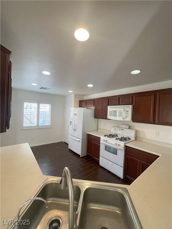 Kitchen with recessed lighting, white appliances,