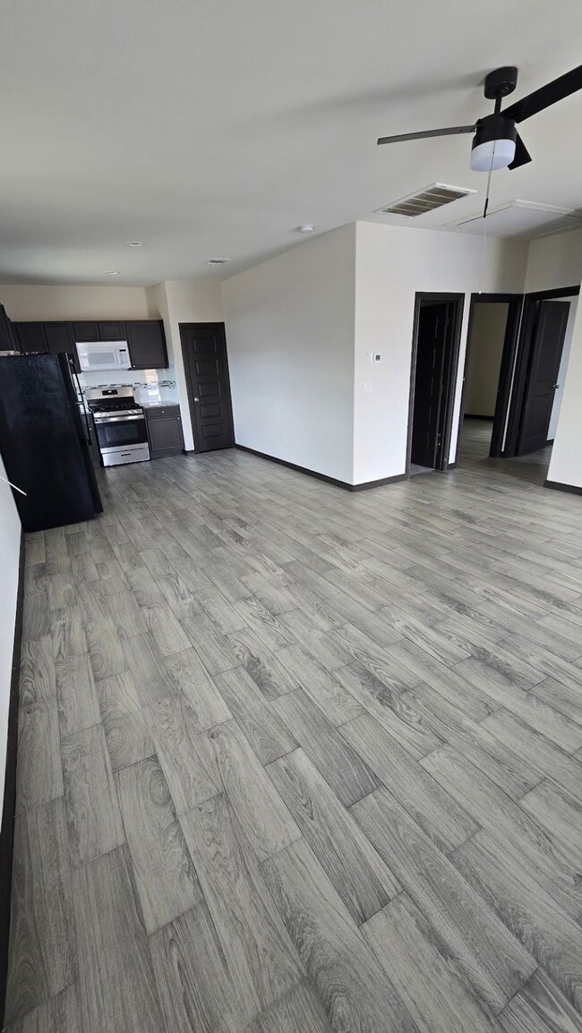 Living area with open floor plan and fan ceiling.
