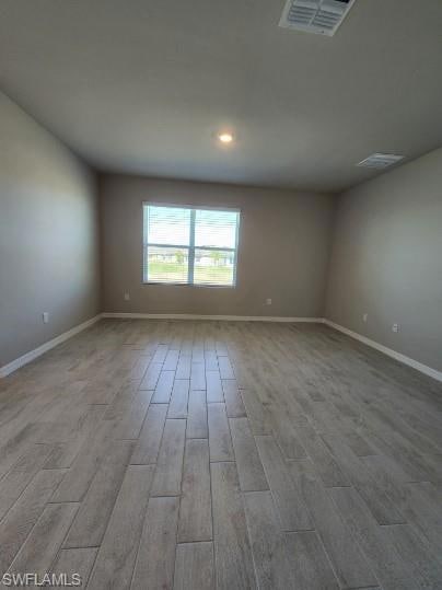 Empty room featuring visible vents, recessed light