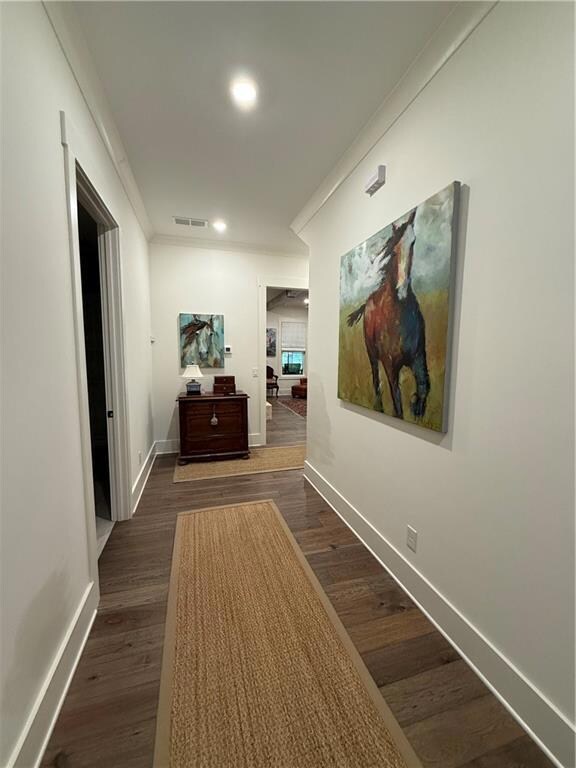 Hallway featuring baseboards, ornamental molding, dark wood-style floors, and recessed lighting