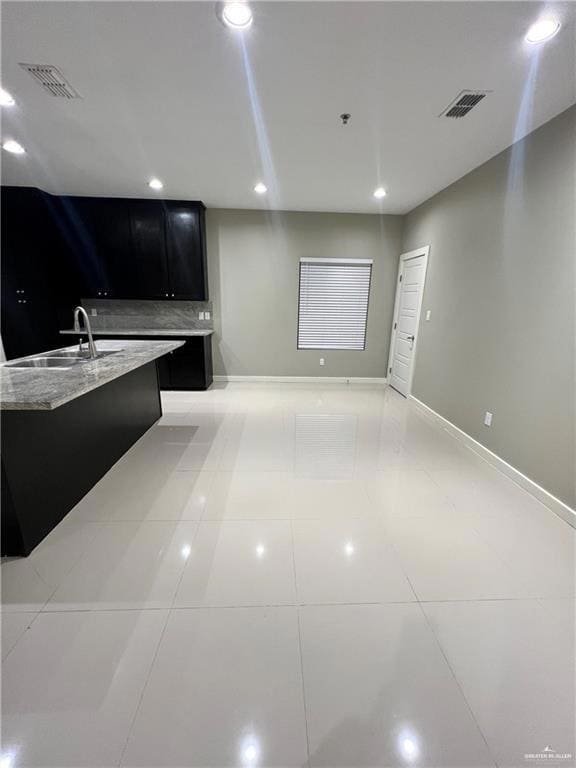 Kitchen with sink, light countertops, and light tile floors