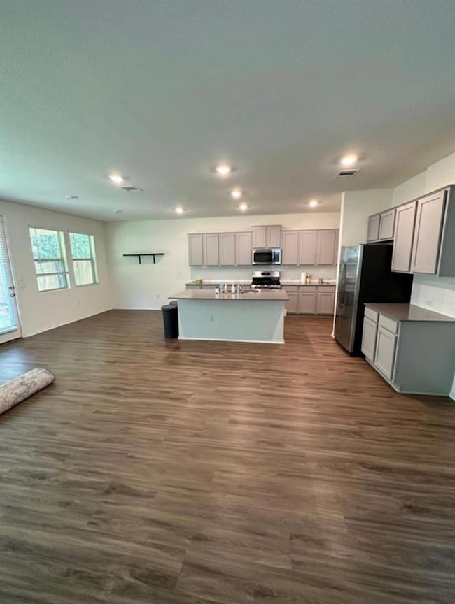 Kitchen with open floor plan, dark wood-style flo