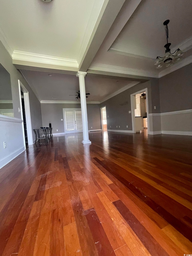 Unfurnished living room with a ceiling fan, ornamental molding, dark wood-style flooring, and ornate columns