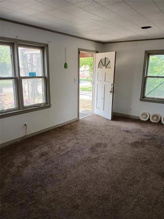 Carpeted spare room featuring baseboards and ornam