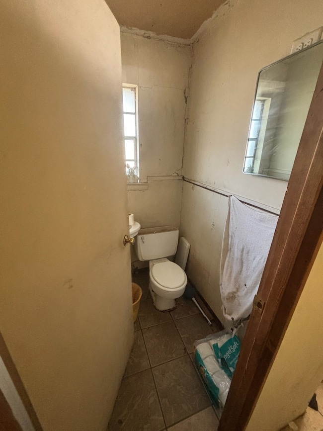 Bathroom with dark tile patterned floors and toilet