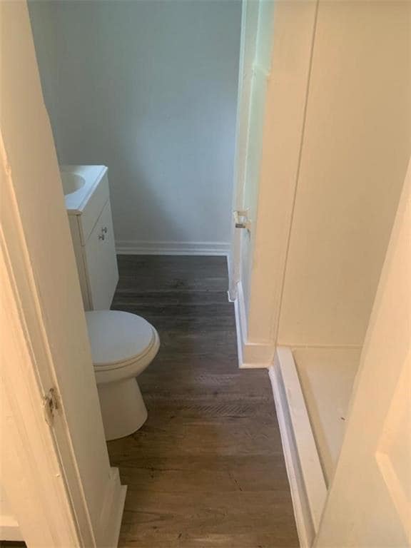 Full bath with vanity, wood finished floors, and a shower