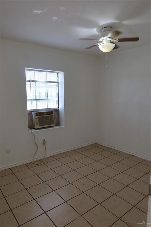 Spare room featuring cooling unit, ceiling fan, and baseboards