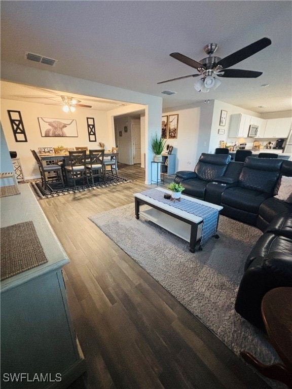 Living room featuring ceiling fan and wood finishe