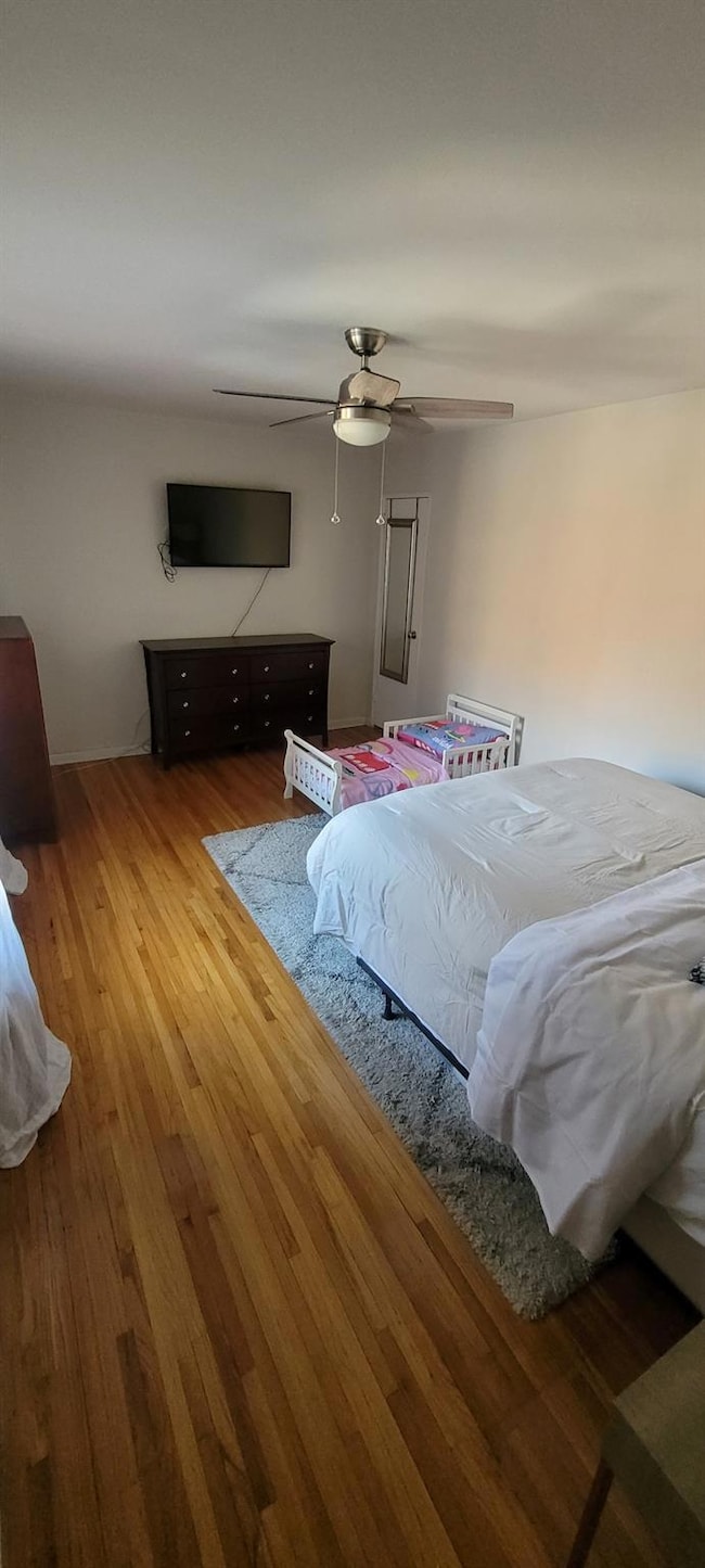 Bedroom with wood finished floors and ceiling fan