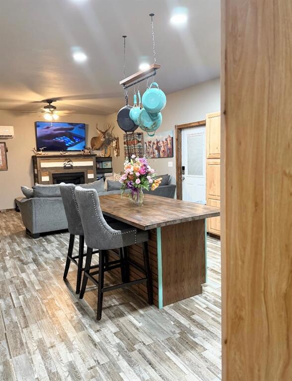 Dining area with an AC wall unit, light wood-style