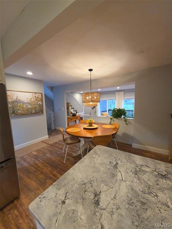 Dining room featuring stairs, dark wood-type flooring, a chandelier, and recessed lighting