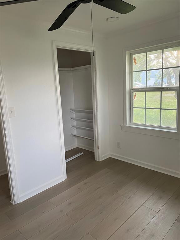 Unfurnished bedroom with a closet, ceiling fan, an