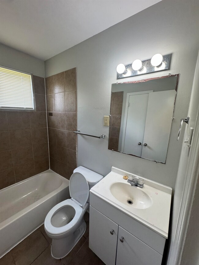 Bathroom featuring vanity, tile patterned flooring, and washtub / shower combination