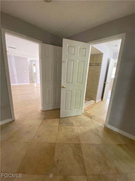 Hall featuring baseboards and light tile patterned floors