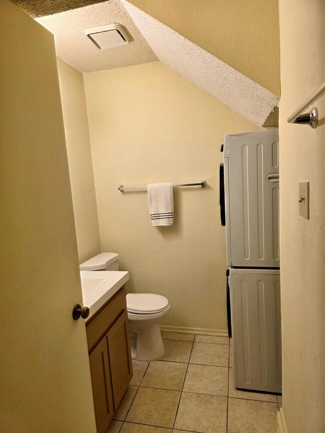Bathroom featuring stacked washer and dryer, visib