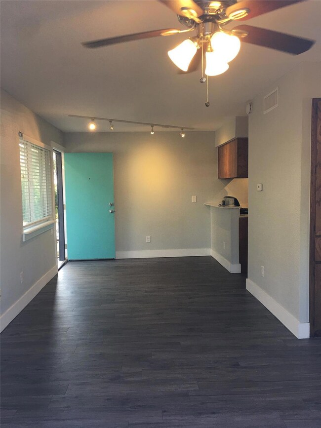 Unfurnished living room featuring track lighting,