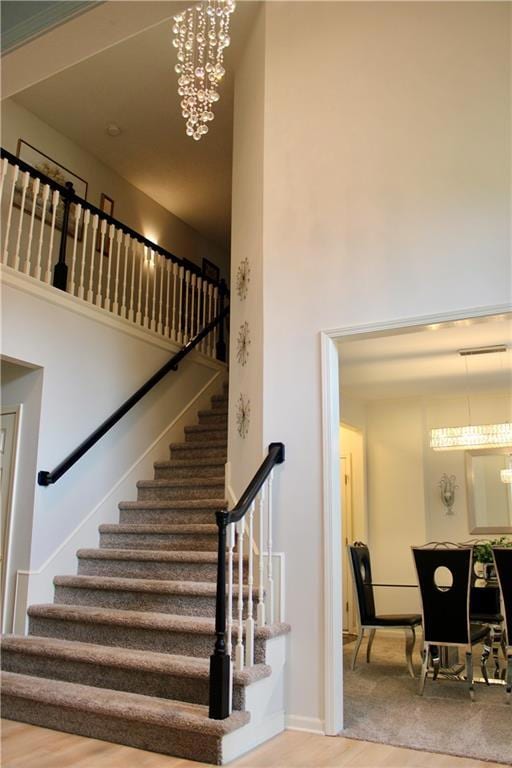 Stairway featuring wood finished floors and a chandelier