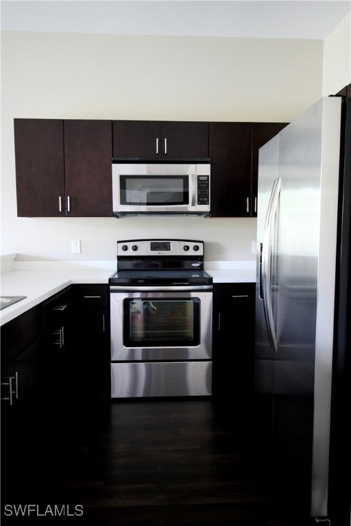 Kitchen with stainless steel appliances, dark wood