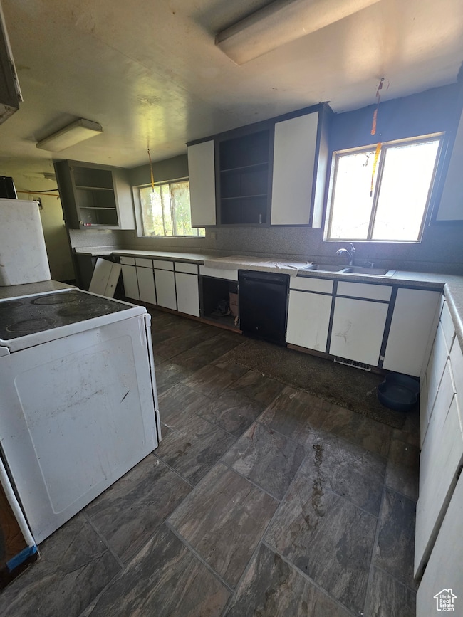 Kitchen featuring white cabinets, open shelves, and pendant lighting