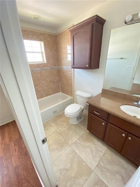 Full bathroom featuring tile patterned flooring, toilet, and vanity