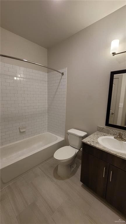 Full bathroom featuring vanity, tiled shower / bath, and toilet