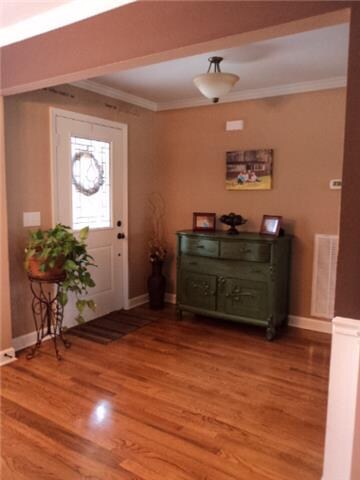 The foyer has custom glass front door.  As you enter from the outside the covered porch has custom design brick detail and enters into the home showing all of the custom features added.