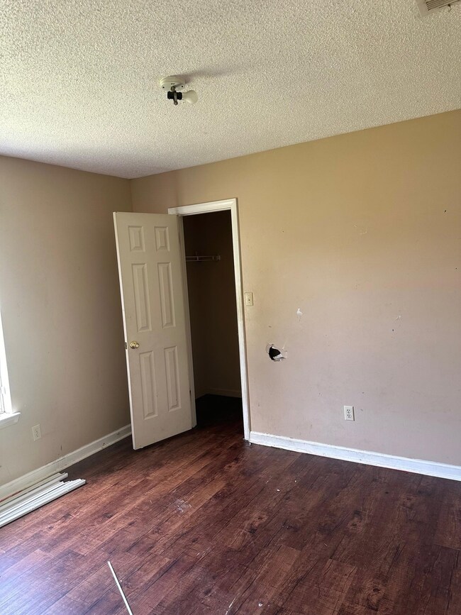 Empty room featuring a textured ceiling and hardwo