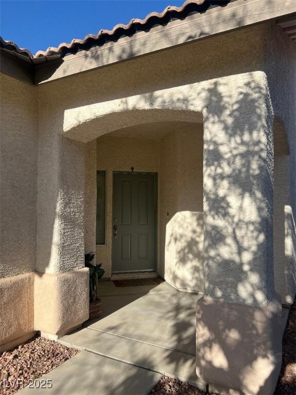 View of exterior entry with stucco siding