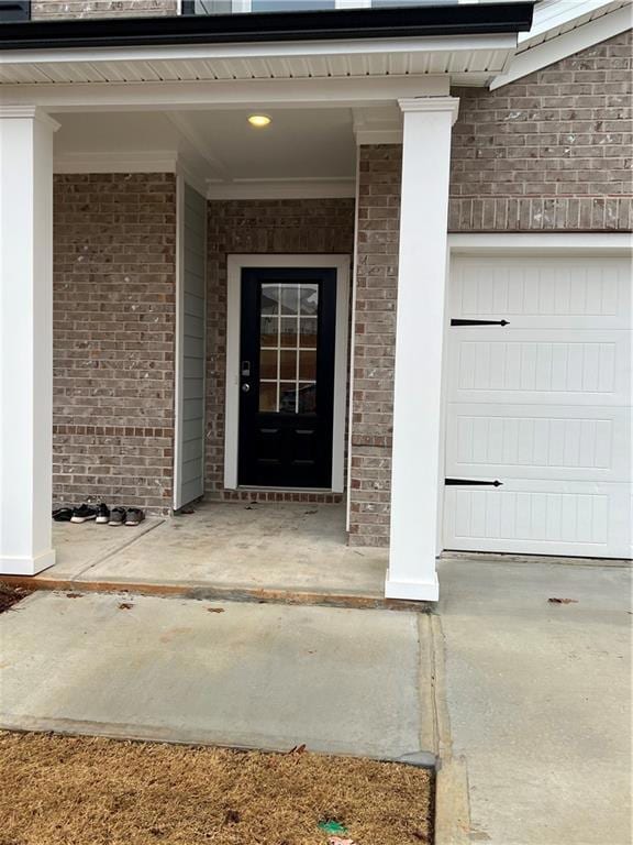 Entrance to property featuring covered porch and brick siding