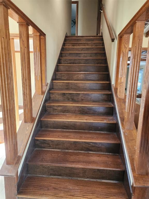 Staircase with a high ceiling and wood finished fl