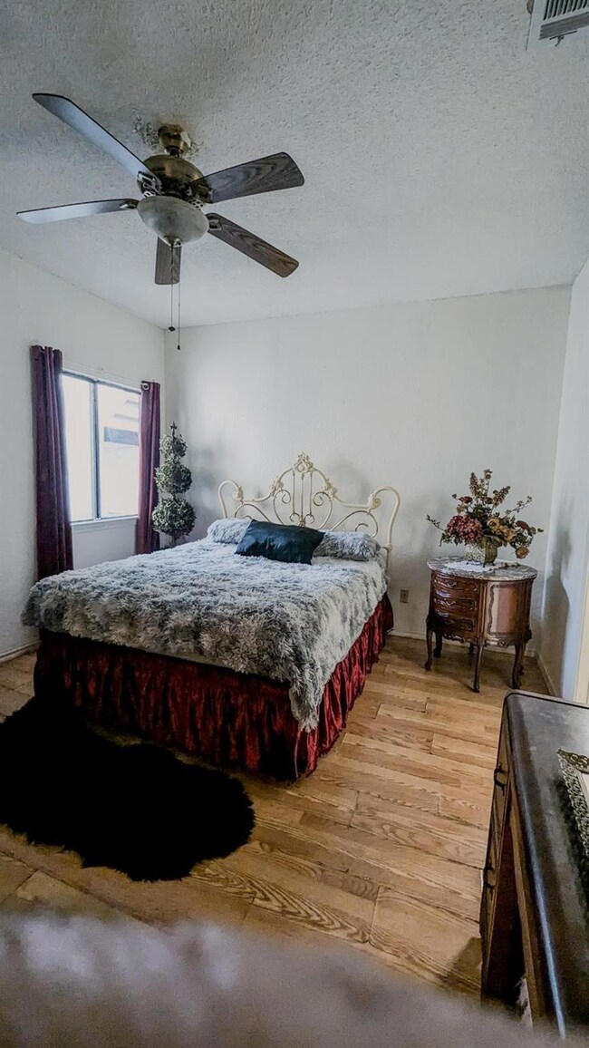 Bedroom with hardwood / wood-style floors, a textu