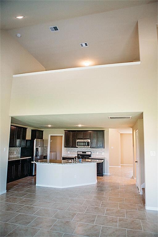 high ceilings and kitchen opens up to living room