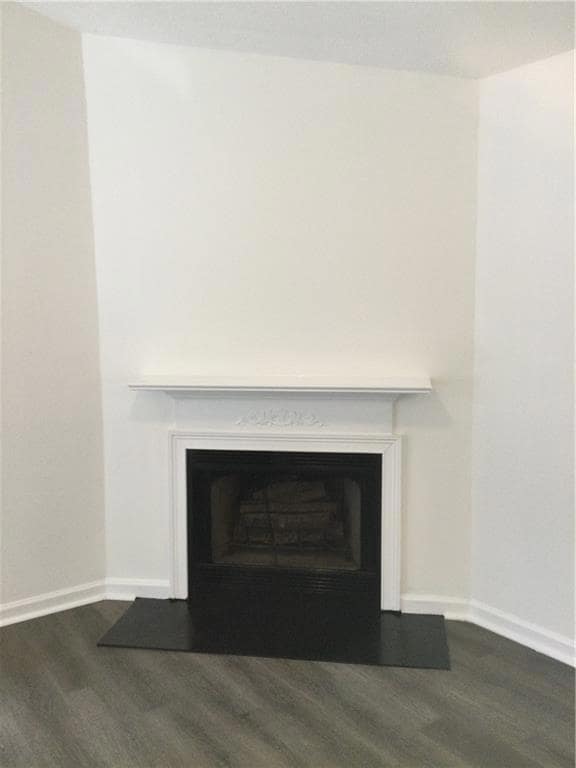 Detailed view of wood finished floors and a fireplace
