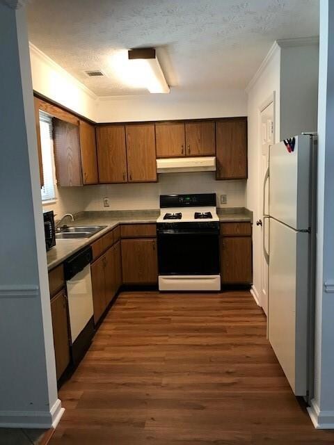 Kitchen featuring  range, sink, dark hardwood / wood-style floors, and fridge