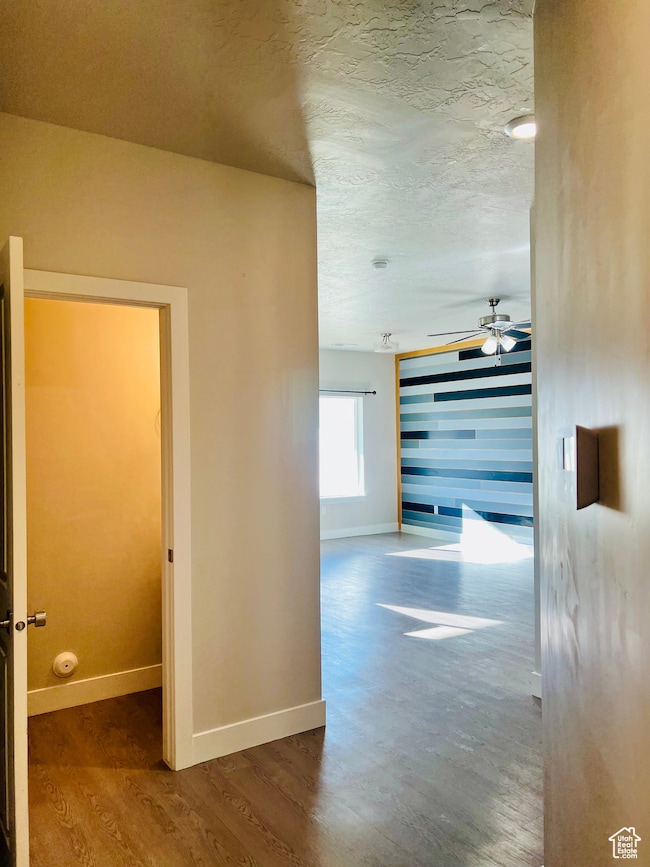 Hallway featuring wood finished floors and a textured ceiling