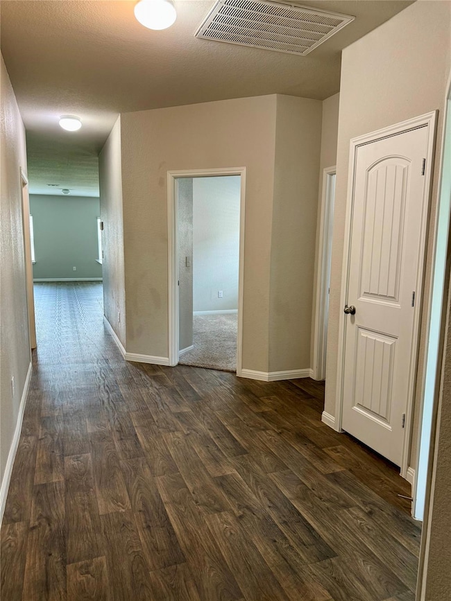 Hallway featuring dark wood finished floors and b