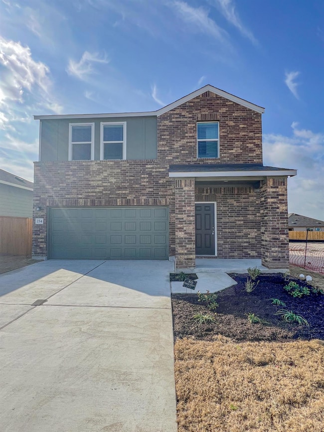 View of front of home with concrete driveway, brick siding, and a garage