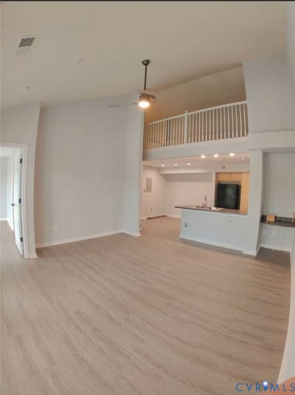 Unfurnished living room featuring light wood-type flooring and baseboards