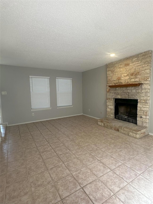 Unfurnished living room featuring a textured ceiling and a fireplace