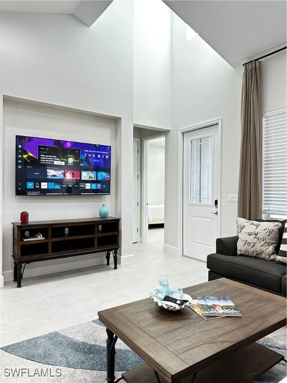 Living room featuring a high ceiling and tile patt