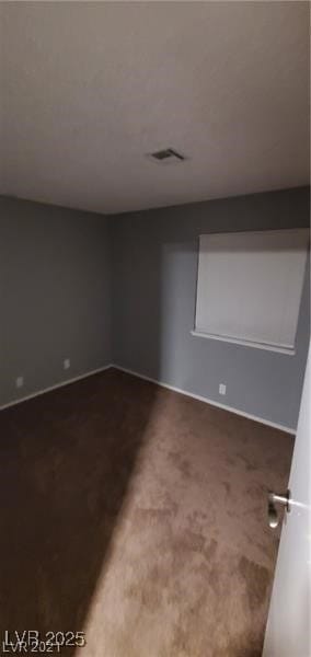 Carpeted spare room featuring baseboards