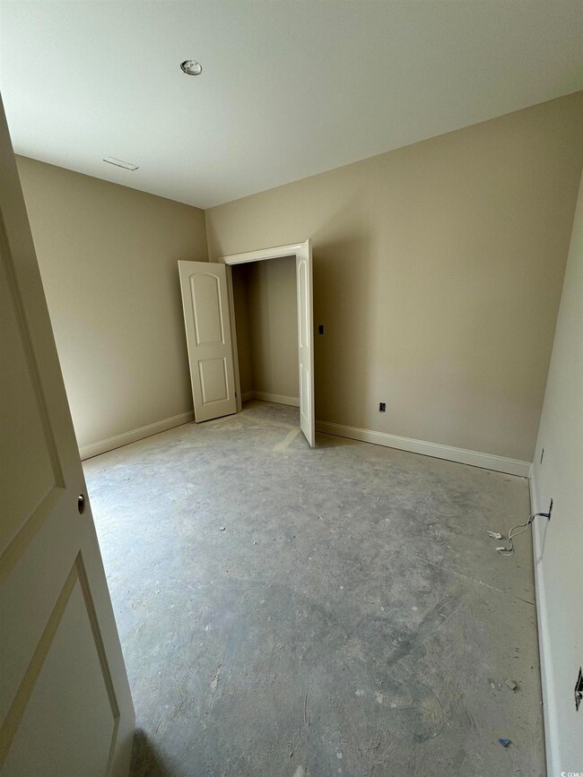 Unfurnished bedroom featuring concrete floors