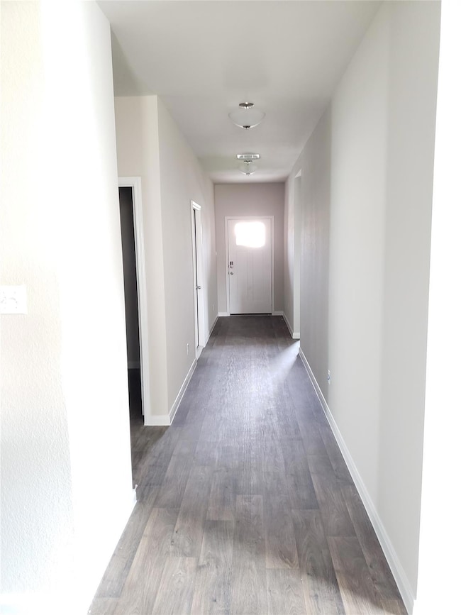 Hallway with light wood finished floors and baseboards