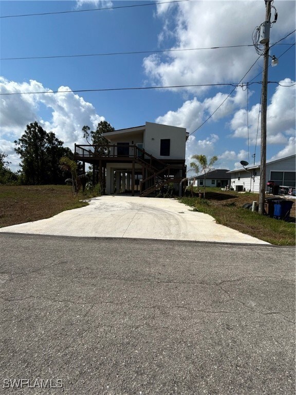 Raised beach house featuring stairway and concrete