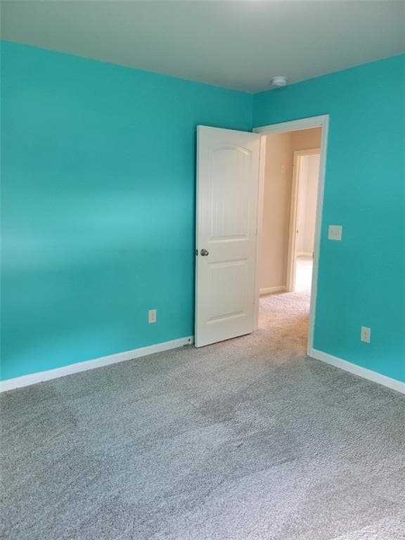 Unfurnished room with carpet flooring and a smoke detector