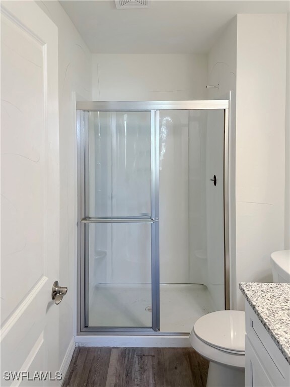 Full bath featuring wood finished floors, toilet,