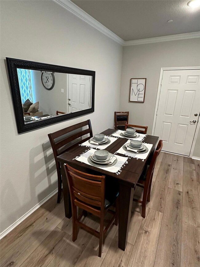 Dining room featuring crown molding and light hardwood / wood-style flooring