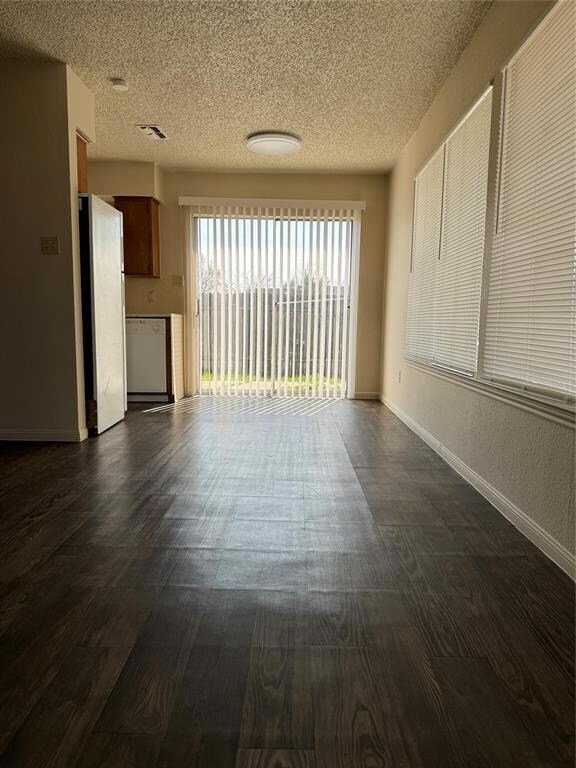 Unfurnished living room featuring a textured ceil